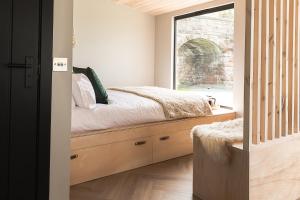 a bedroom with a bed and a window at Off the Track Scotland, Luxury Lodge in Crail