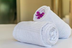 a roll of toilet paper with a purple flower at Praieiro pousada in Prea