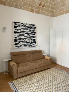 una sala de estar con sofá y una pintura en la pared en n°21 (Casa di Anna), en Copertino
