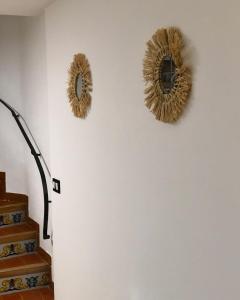 two mirrors on a wall next to a staircase at La Casita de Peñíscola - Somhome in Peñíscola