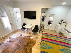 a living room with a table and a tv at Frederick Motel in Fredericksburg