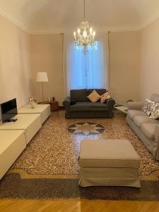 sala de estar con sofá y lámpara de araña en Casa Galliera Bologna Centro, en Bolonia