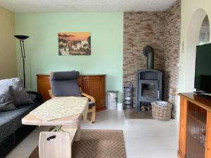 een woonkamer met een bank en een houtkachel bij Ferienhaus auf Usedom, Neeberg in Krummin