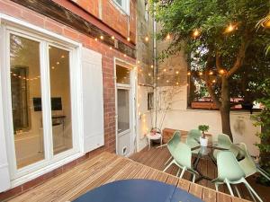 un patio avec une table et des chaises et un bâtiment dans l'établissement Grand Appartement Haussmanien de Standing avec Jacuzzi Terrasse et Parking en Hyper Centre, à Bordeaux