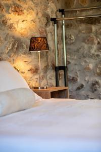 a bedroom with a bed and a lamp on a table at V&M Traditional Luxury Villa in Tolo