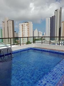 a swimming pool on top of a building with tall buildings at Cantinho Aconchegante 304 Praia - Tambaú in João Pessoa