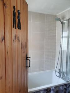 uma casa de banho com um chuveiro e uma banheira branca em Wales' Highest Village - The Chartist Cottage - Trefil em Tredegar