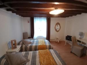 a bedroom with two beds and a dog sitting in the window at La Briarde triple PDJ in Boissy-le-Châtel