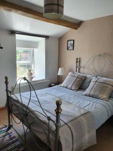 1 dormitorio con 1 cama grande con marco de metal en Wales' Highest Village - The Chartist Cottage - Trefil, en Tredegar