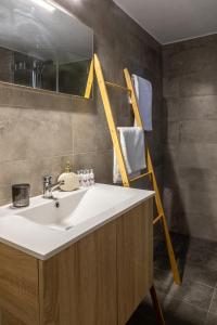 a bathroom with a sink and a mirror and a towel rack at V&M Traditional Luxury Villa in Tolo