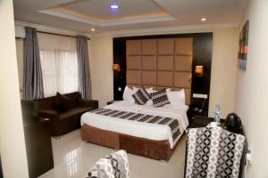 a bedroom with a king sized bed and a couch at CLASS COTTAGE in Ikeja