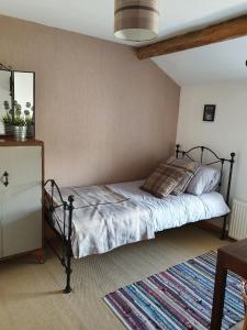 a bedroom with a bed and a dresser at Wales' Highest Village - The Chartist Cottage - Trefil in Tredegar