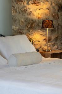 a bed with a pillow and a lamp on a table at V&M Traditional Luxury Villa in Tolo