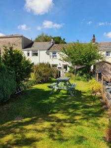 a picnic table in the grass in front of a house at Wales' Highest Village - The Chartist Cottage - Trefil in Tredegar