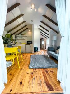 a living room with a yellow table and a kitchen at Holmdale Holiday Cottages in Rye