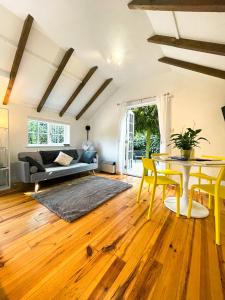 a living room with a table and yellow chairs at Holmdale Holiday Cottages in Rye