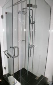 a shower with a glass door in a bathroom at CLASS COTTAGE in Ikeja