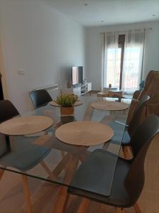 uma sala de estar com uma mesa de vidro e cadeiras em El SUEÑO DE LA MANCHA em Mota del Cuervo