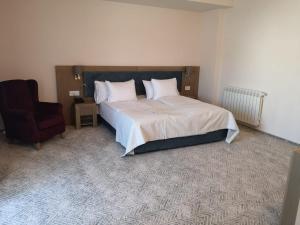 a bedroom with a large bed and a chair at New Wolf in Bran