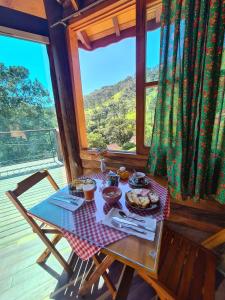 una mesa con comida en ella en una habitación con ventana en Chales Encanto do sol en Visconde De Maua