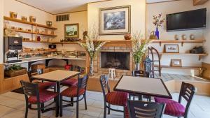 uma sala de jantar com mesas e cadeiras e uma lareira em Apple Tree Inn; SureStay Collection by Best Western em Petoskey