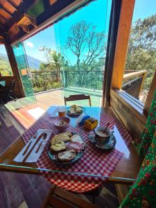 uma mesa com um prato de comida em cima em Chales Encanto do sol em Visconde de Mauá