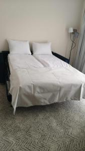 duże łóżko z białą pościelą i poduszkami w obiekcie New Wolf w mieście Bran