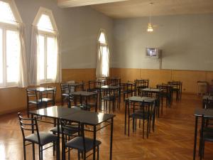 an empty room with tables and chairs and windows at Hotel Du Helder in Buenos Aires