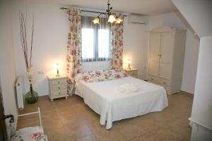 a bedroom with a white bed and a window at Casas Rurales Cazorla-Alcón in Pozo Alcón