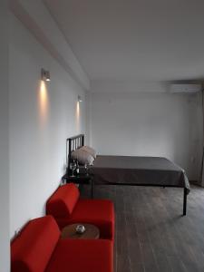 a room with a bed and a red couch at Apartment 334 - Modern Lakeview Apartment in Struga