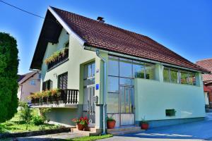 a white house with windows and plants on it at Ivana in Saborsko