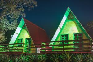 una casa con techo rojo y verde en Pousada Recanto da Lua en Caparaó Velho
