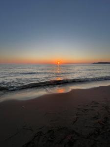 een zonsondergang op een strand met de oceaan bij Vila Gjiri Lalzit in Durrës