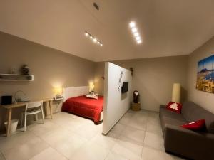 een slaapkamer met een bed, een bureau en een bank bij PortaMedina House in Napels