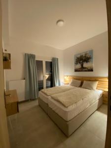 Un dormitorio con una cama grande y una ventana en Villa Olymp, en Nea Potidaea
