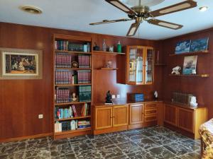 a room with wooden bookshelves and a ceiling fan at Elche Holidays in Elche
