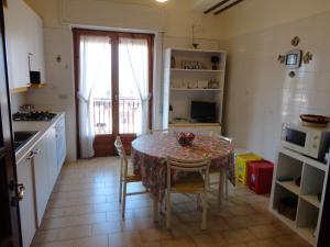a kitchen with a table and chairs in a kitchen at Casa delle Pomelie - Taormina & Etna Panoramic Views in Riposto