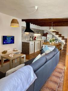 LentegíにあるCasa Bodijar - Casa Rural en Lentegiの青いソファとキッチンのあるリビングルーム