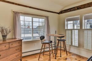 a room with two stools and a table and two windows at The Burrell House in Keene