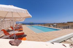 einen Pool mit einem Tisch, Stühlen und einem Sonnenschirm in der Unterkunft Villa Ostrich in Fira