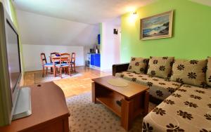 - un salon avec un canapé et une table dans l'établissement Apartments Alan, à Saborsko