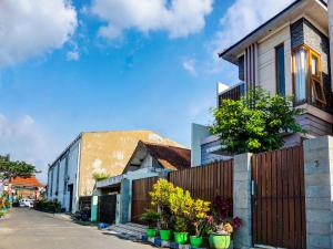 a row of houses with potted plants on a street at SPOT ON 91530 Sumpil Syariah in Malang