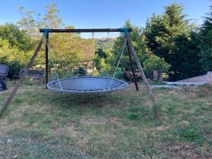 an empty swing in a yard with a field at Logement indépendant avec jardin à Rodez Aveyron in Onet le Château