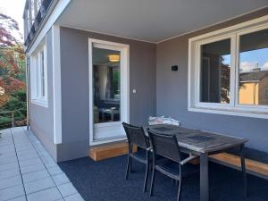 a table and chairs on a patio with a window at Ferienwohnungen Brunmayr in Gmunden