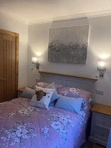 a bedroom with a purple bed with pillows at Ben Nevis Manor Lodge & Indoor Private Hot-Tub in Fort William