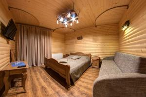 Lavina Hotel في بوكوفِل: غرفة نوم بسرير واريكة في غرفة