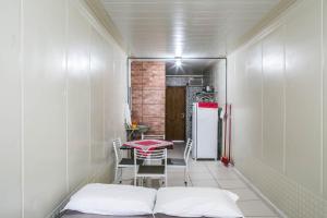 a small room with a table and a refrigerator at Estúdio e Suítes com Piscina, churrasqueira, AR Split, WIFI - 6x sem juros no cartão in Porto Belo