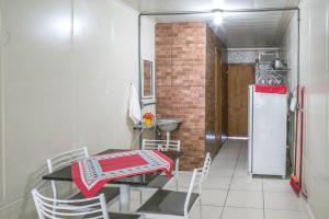 a small kitchen with a table and a refrigerator at Perto da Meia Praia e do Píer com Cozinha Garagem Ar Wi-Fi e Enxoval - CASA OLINDA in Porto Belo