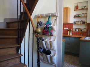 a kitchen with a refrigerator with shoes and a staircase at Les Vergers de Cussy in Cussy-en-Morvan