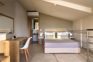 Schlafzimmer mit einem Bett, einem Schreibtisch und einem Tisch in der Unterkunft Grapevines Hotel in Alikanas